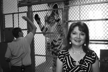 Photo of Karen Stierer with a tiger and its trainer in the background